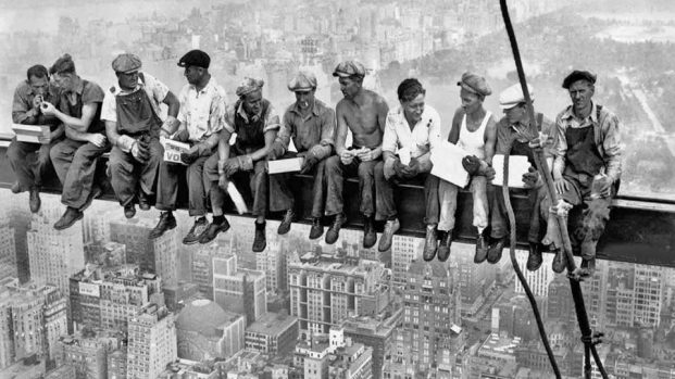 Obreros sentados en viga de rascacielos